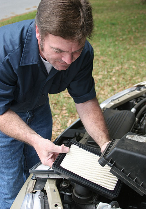 auto mechanic replacing an air filter